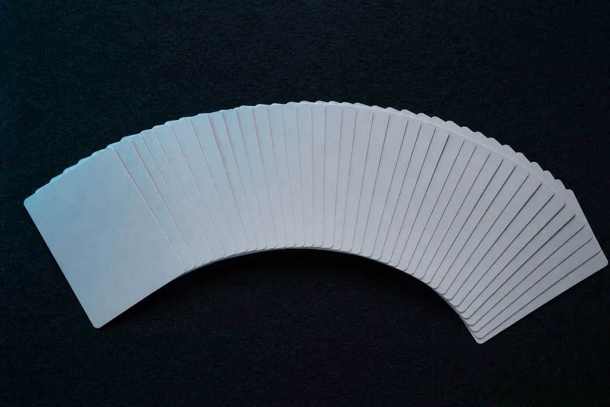 Éventail de cartes à jouer étalées face cachée sur un tapis sombre