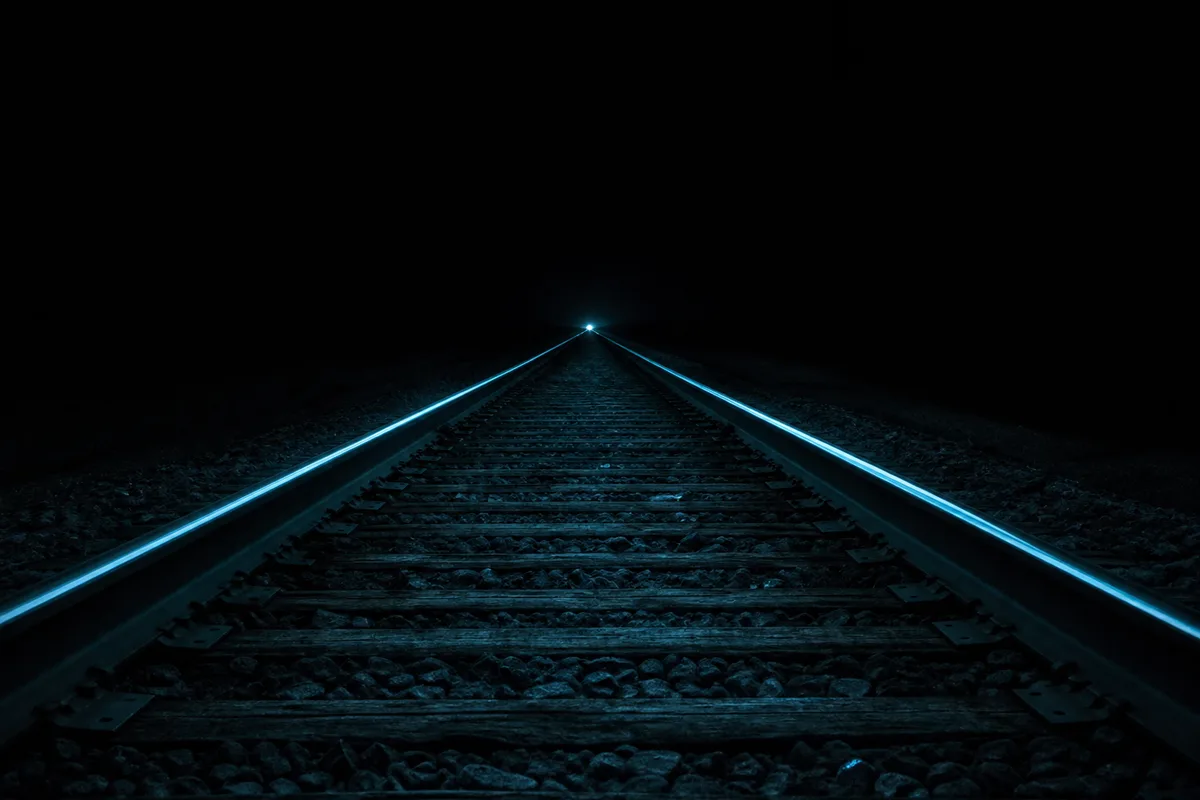 Rails de chemin de fer convergents dans la nuit