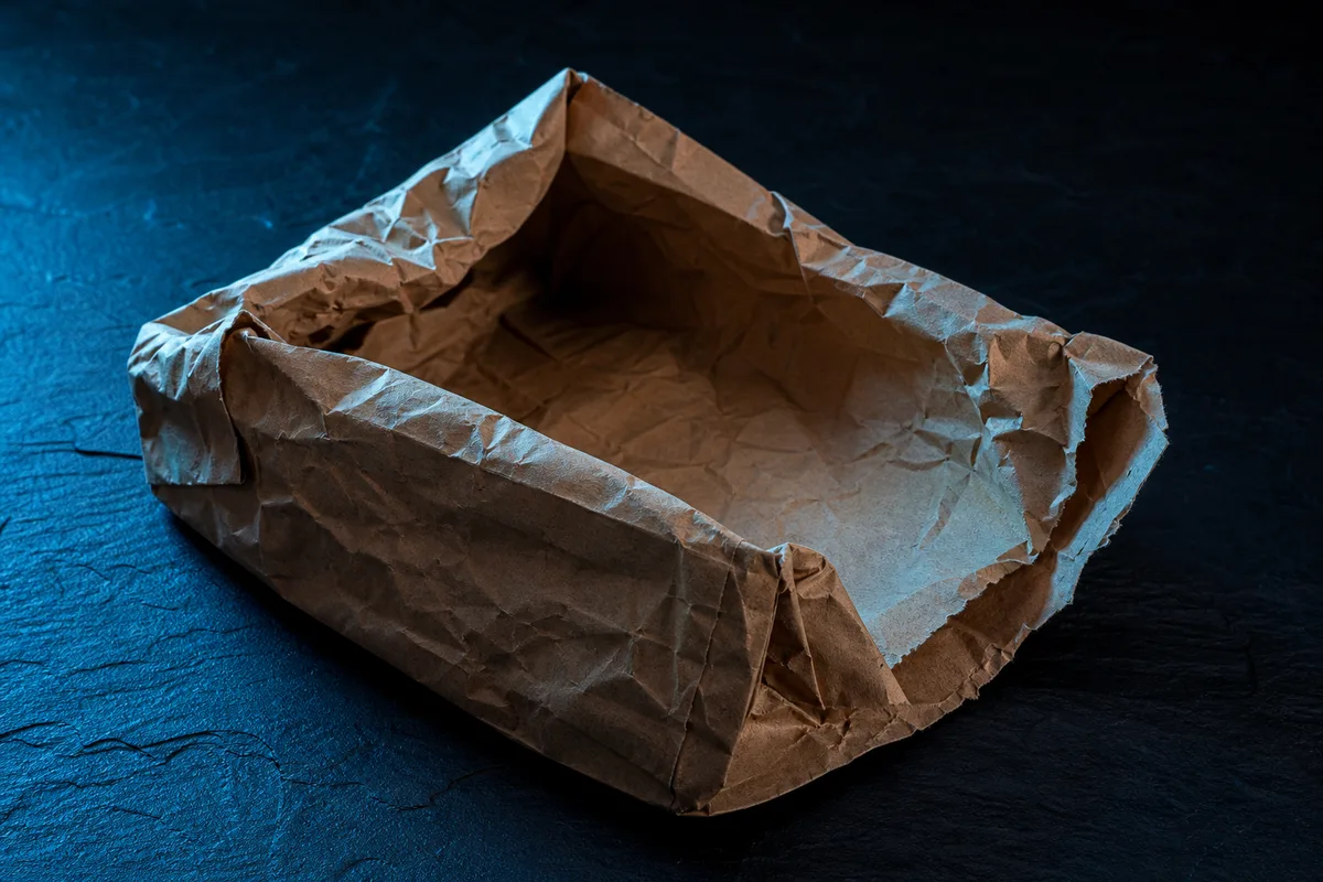 Emballage vide et froissé posé sur une surface sombre